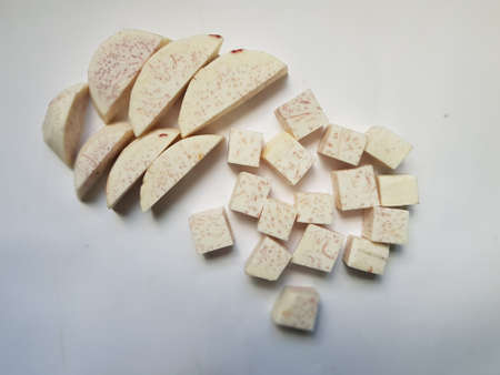 Taro slices and cube was cuted for cooking new dishes  on white and wood background.の写真素材