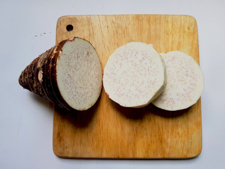 Taro slices and cube was cuted for cooking new dishes  on white and wood background.の写真素材