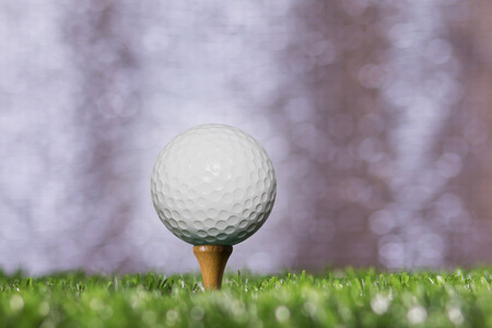 Golf ball on a tee peg bokeh background silver.の写真素材