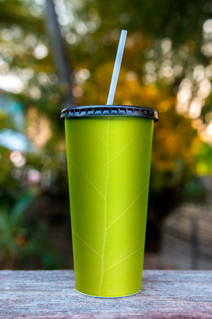 Paper cups with green florals, nature backgroundの写真素材