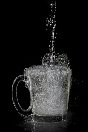 water splash in glass on black backgroundの写真素材