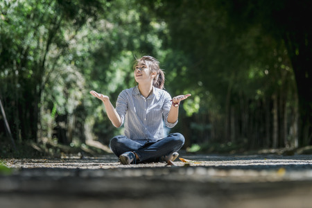 happy woman sitting on the ground  in the forest.の写真素材