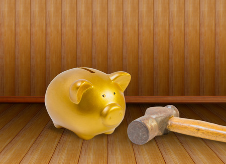 piggy bank and old hammer on wood background. Concept about saving moneyの写真素材