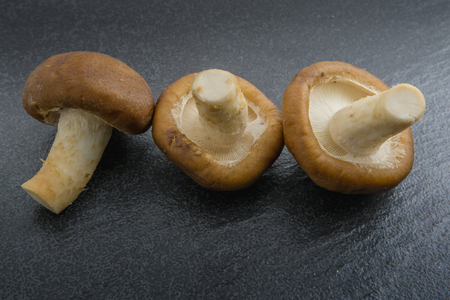 Close up raw shiitake mushrooms on black backgroundの写真素材