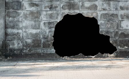 Old concrete brick wall broken and black hole for use backgroundの写真素材