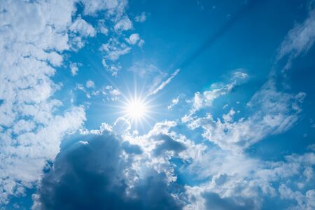 blue sky with clouds and sun shines with sunbeams in the dayの写真素材