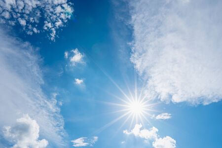 sun on blue sky with sunbeams and clouds in the dayの写真素材