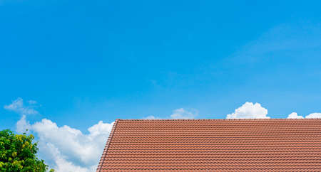 Red roof tiles and treetops on blue sky with copy spaceの写真素材