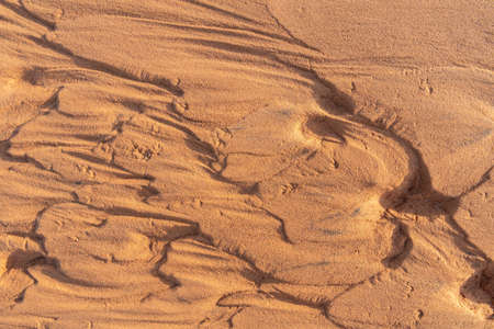 Nature closeup background of dry sand after water flows with shadowsの写真素材