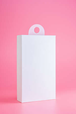 white cardboard package box mockup isolated on pink background with hangerの写真素材