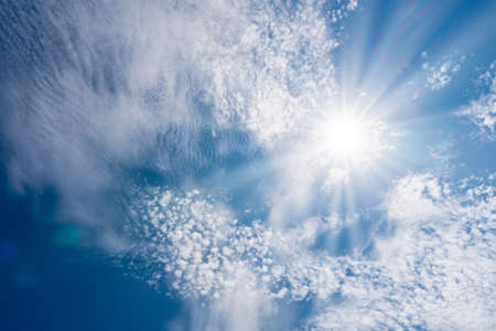 beautiful nature of blue sky with clouds and sun shines bright in the dayの写真素材
