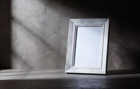 empty wooden white old style picture frame on concrete background with shadow window, copy spaceの写真素材