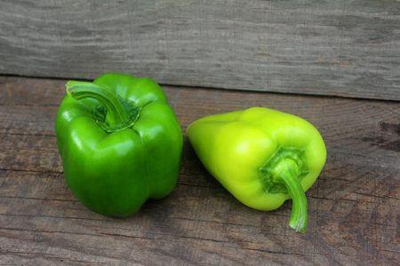 Two Ripe Green pepper lying on a wooden background.の写真素材