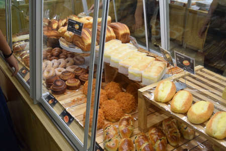 Coffee shop window with a variety of pastries and cakesの写真素材