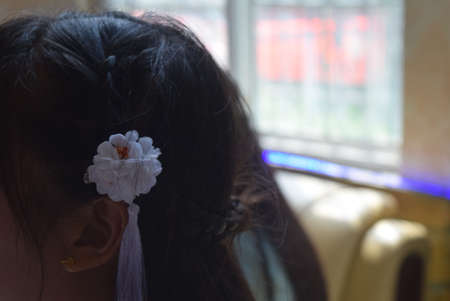 Close up of a little girl with a flower in her hair.の写真素材