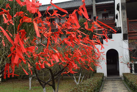 Red ribbons hanging in front of the entrance to a Buddhist templeの写真素材