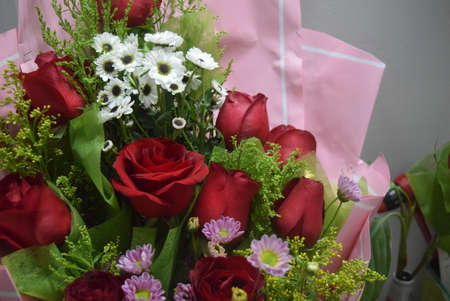 Bouquet of red roses, daisies and chamomilesの写真素材