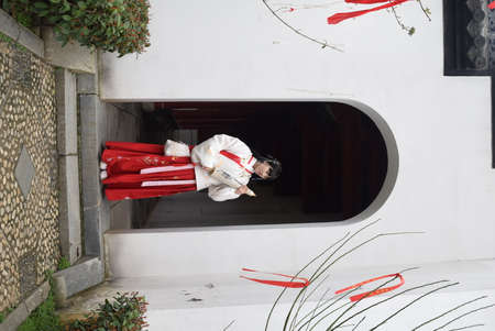 A girl in a red kimono in the streets of Hochiminh City.の写真素材