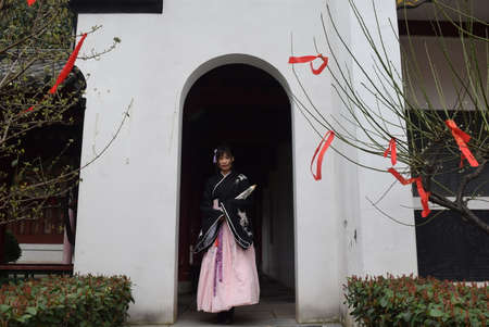 Japanese woman in kimono and kimono walking in front of a door in a temple in Kyoto, Japanの写真素材