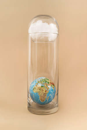 Abstract creative minimal composition. Travel and environment concept with glass bottle, seashells, cloud and umbrella shadow on beige background. Frontal view.の写真素材