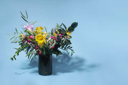 Bouquet of flowers on a blue background. Multicolored flowers with shadows on a light blue background. Front view.の写真素材