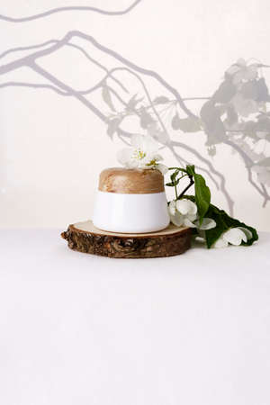 Skin care cream on a white background with apple tree branches. Front view.の写真素材