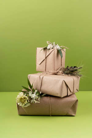 Eco Christmas gift boxes, copy space. Frontal view. On a green background.の写真素材