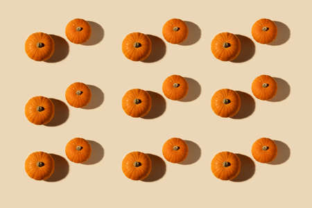 Creative autumn composition. Pumpkins on pastel beige background. Autumn, halloween concept. Flat lay, top view, copy spaceの写真素材