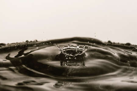 Drops of water falling on smooth wet surface. Blurred background.の写真素材