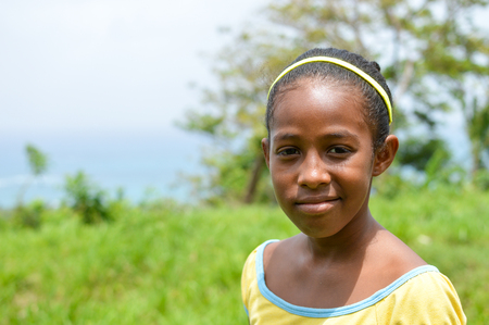 Great Corn Island, Nicaragua - July 6, 2015:  Beautiful Creole girl poses and smiles wearing funky colors on July 6, 2015 in Great Corn Island, Nicaragua.のeditorial素材