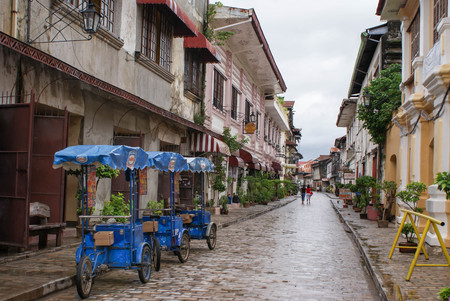 Vigan, Philippines - June 17, 2009: People and tricycles are seen in the beautiful colonial cobblestone streets of Vigan in North Luzon, Philippines. Unesco World Heritage Siteのeditorial素材