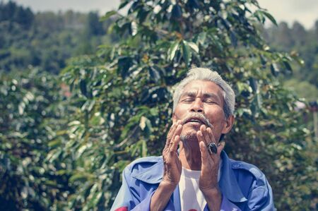Sumatra, Indonesia - January 13, 2018: Elderly Batak farmer is seen next to his coffee plantation in Samosir Island, Lake Toba, Sumatra, Indonesia.のeditorial素材