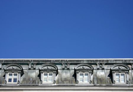 old grey dormer window with blue sky