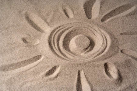 draw of a sun on fine sandの写真素材