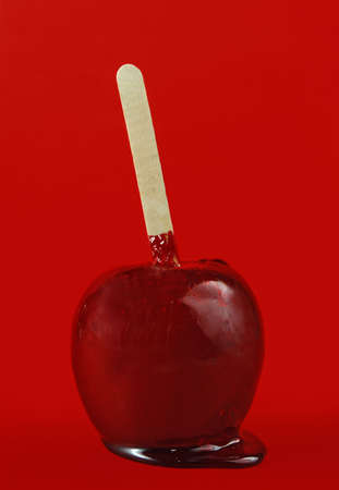 red candy apple on red backgroundの写真素材