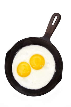 sunny side-up egg on a black cast iron panの写真素材