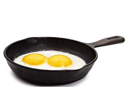sunny side-up egg on a black cast iron panの写真素材