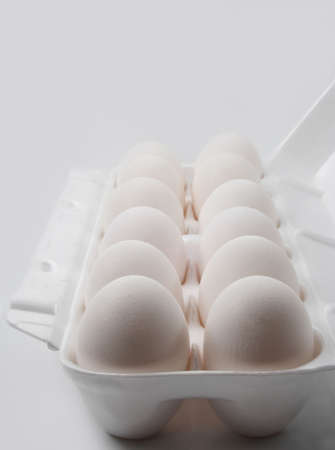dozen of white eggs in its containerの写真素材