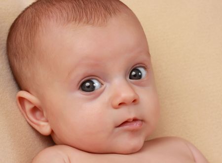 portrait of a cute caucasian baby girl, beige background