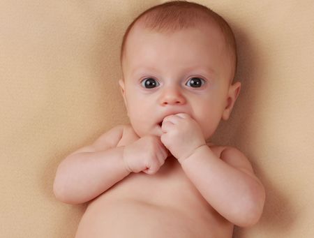 portrait of a cute caucasian baby girl, beige background