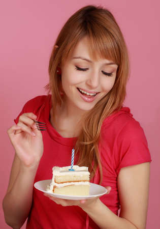 cute girl looking at vanilla birthday cakeの写真素材