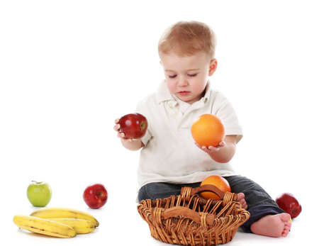 cute one year baby boy with fruit basket, isolated on whiteの写真素材
