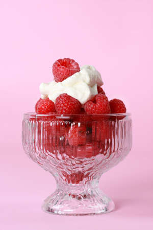 fresh raspberries in glass bowl, pink backgroundの写真素材