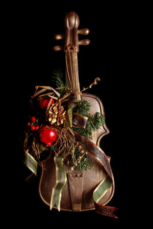 fake violin as christmas ornament, black backgroundの写真素材
