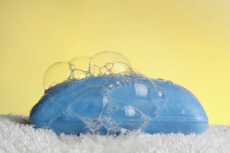 blue soap bar on bath towel, yellow backgroundの写真素材