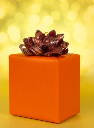 orange gift box with assorted bow, yellow backgroundの写真素材
