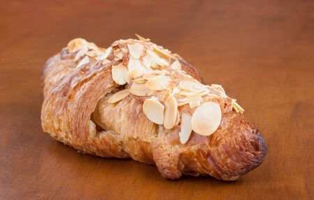 Close-up on tasty French almond crescent on wood table