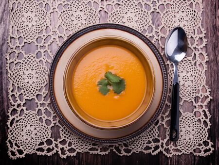 Closeup to vieuw on a carrot cream-soup with cilantroの写真素材