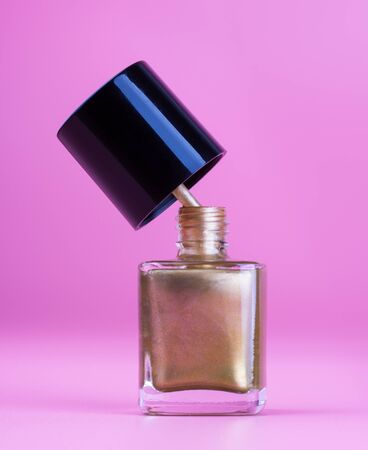 Nice bottle of gold nail polish, pink backgroundの写真素材