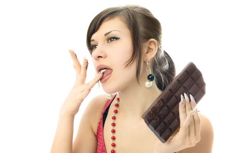 beautiful young brunette woman eating a bar of chocolateの写真素材